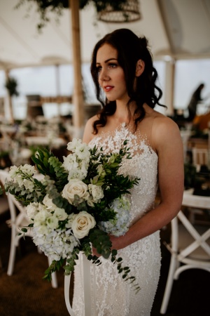 Bride standing in a marquee with white flowers