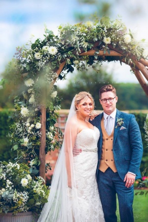 Bride and Groom standing in the wedding ceremony archway