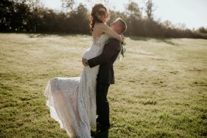 Groom lifting a bride outside